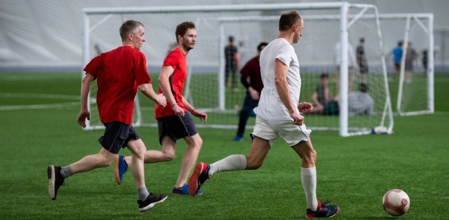 adults are playing football indoor 